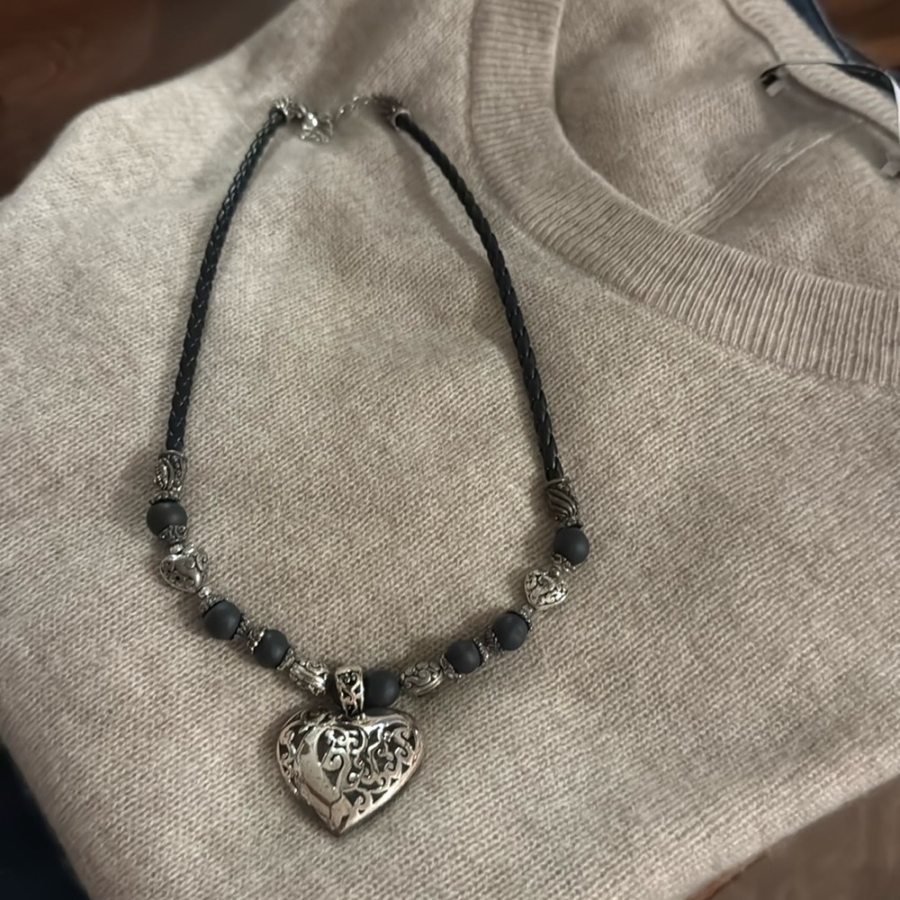 Beautiful necklace with black braided leather chain holding the silver heart